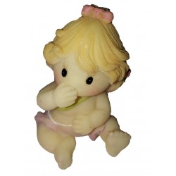 Figurine miniature petite fille assise par terre se touchant la bouche